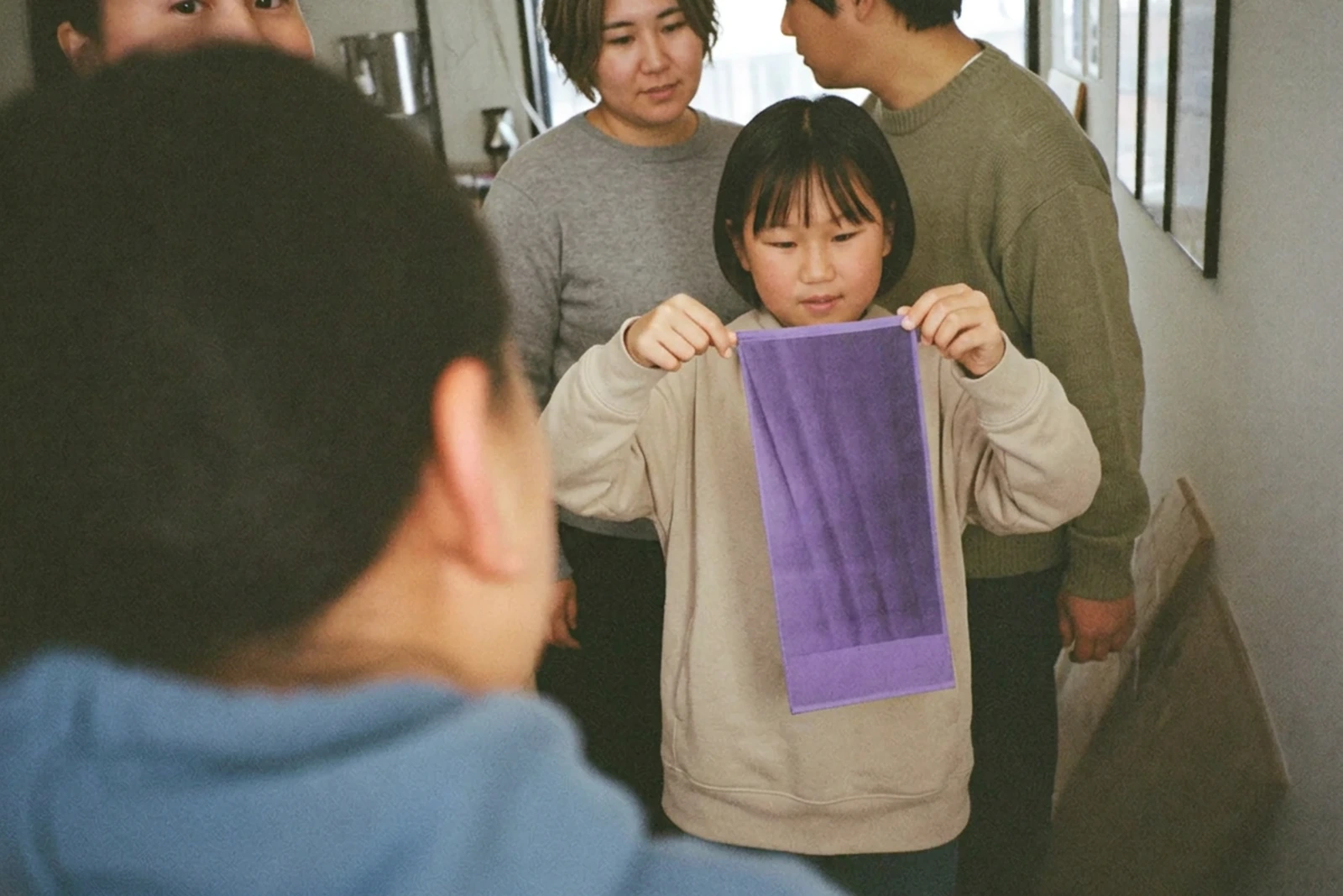 紫に染まった布を広げる女の子