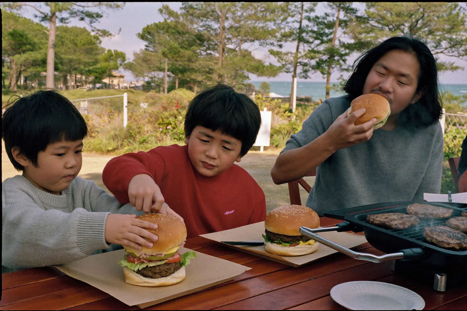 自分で作ったハンバーガーを食べる家族