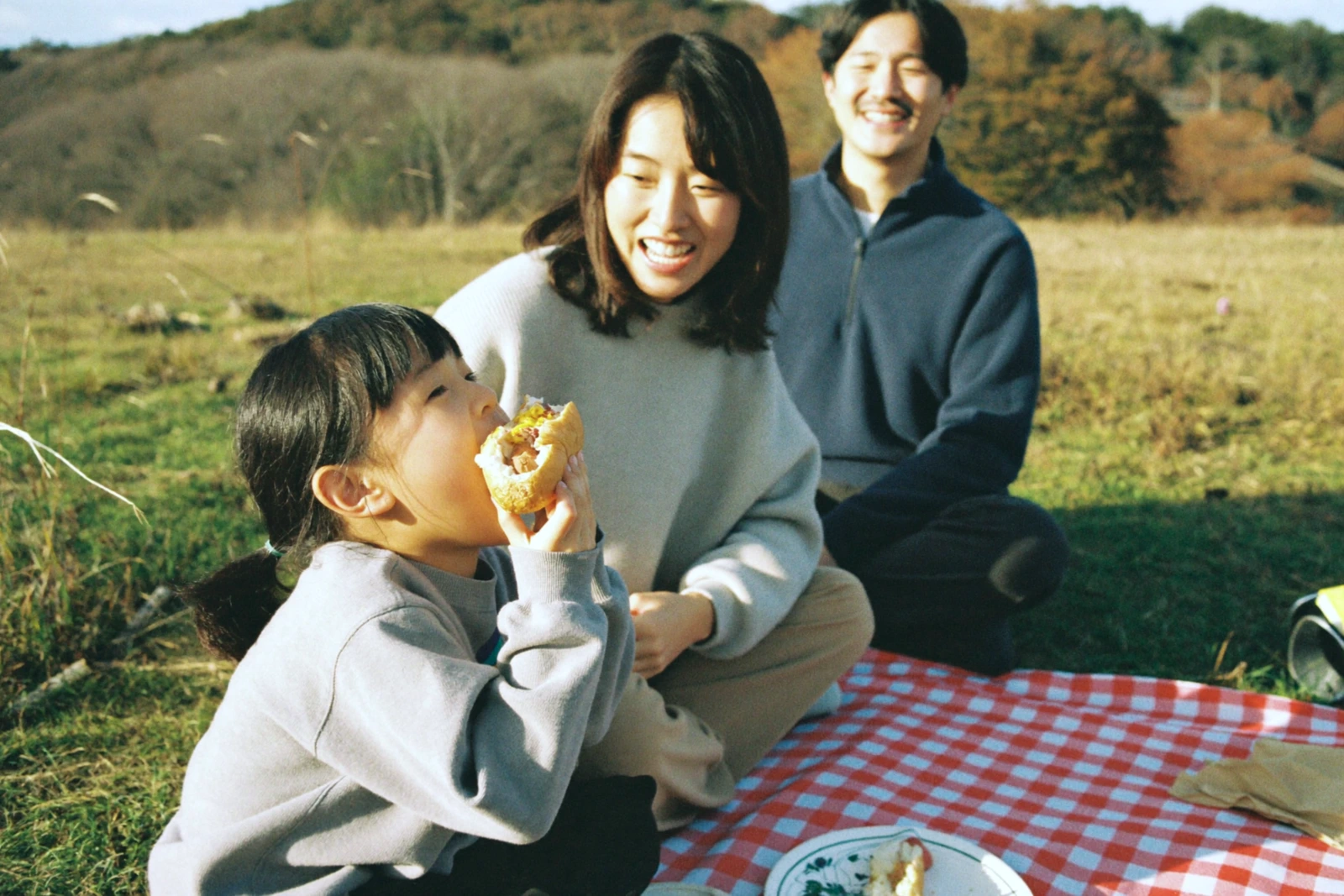 芝生でピクニックをする家族