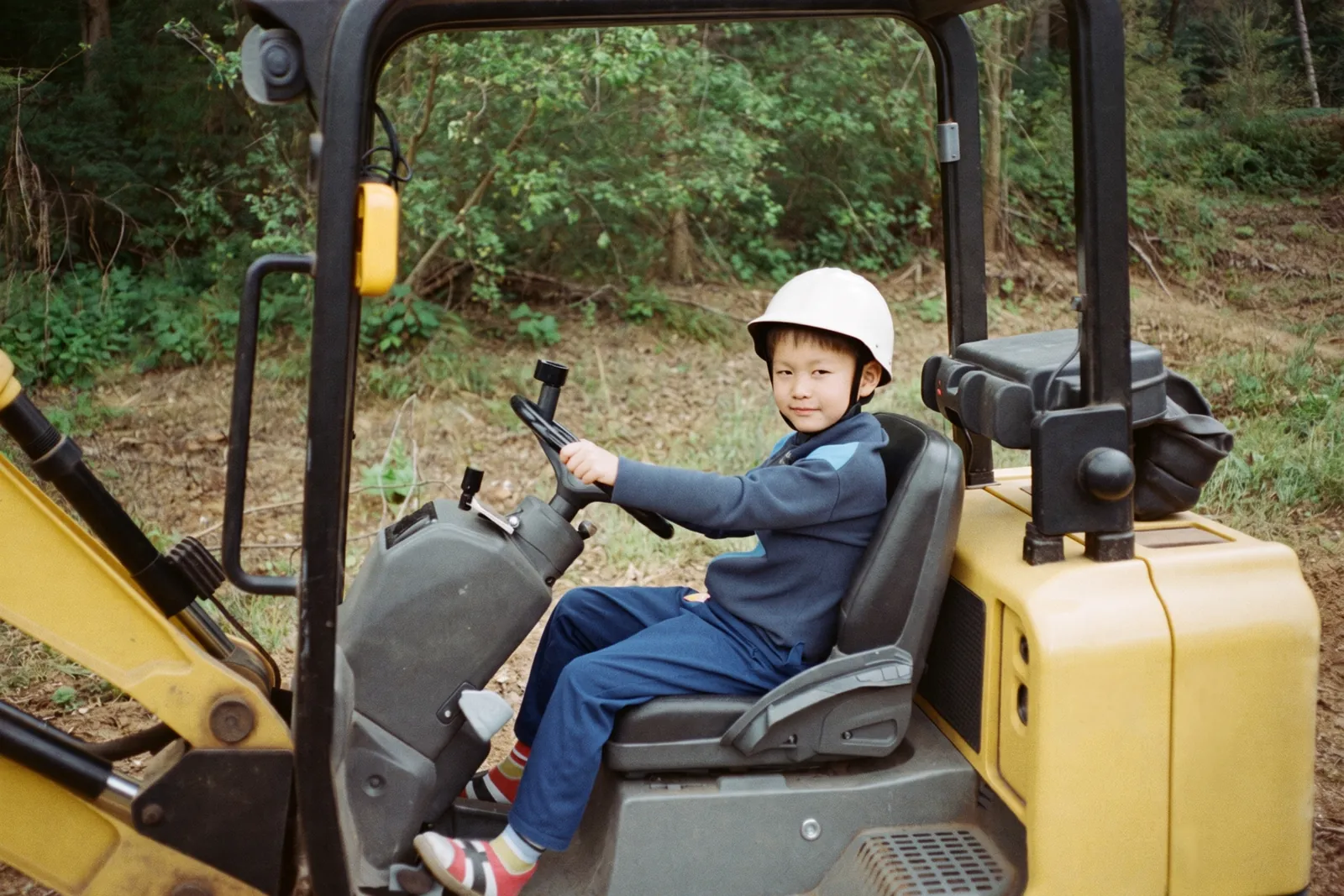 ショベルカーの運転席に座る男の子