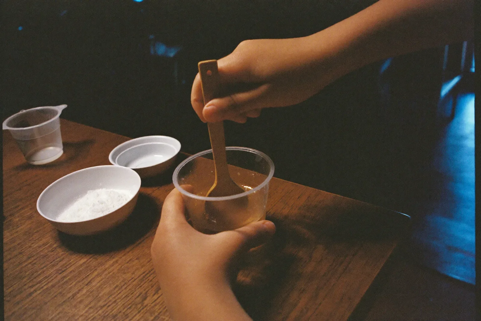粉と液体を混ぜる子どもの手