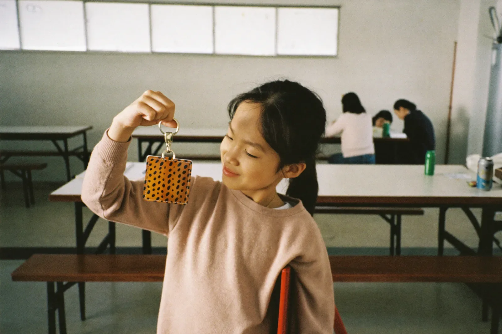 印伝のキーホルダーを見せる女の子