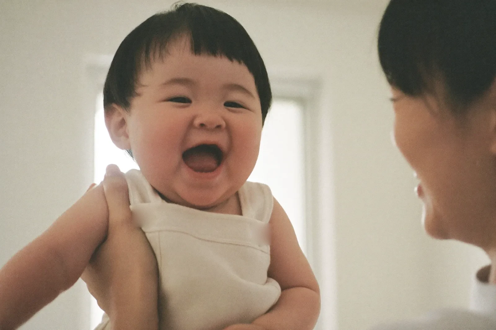 ママに抱かれて笑う赤ちゃん