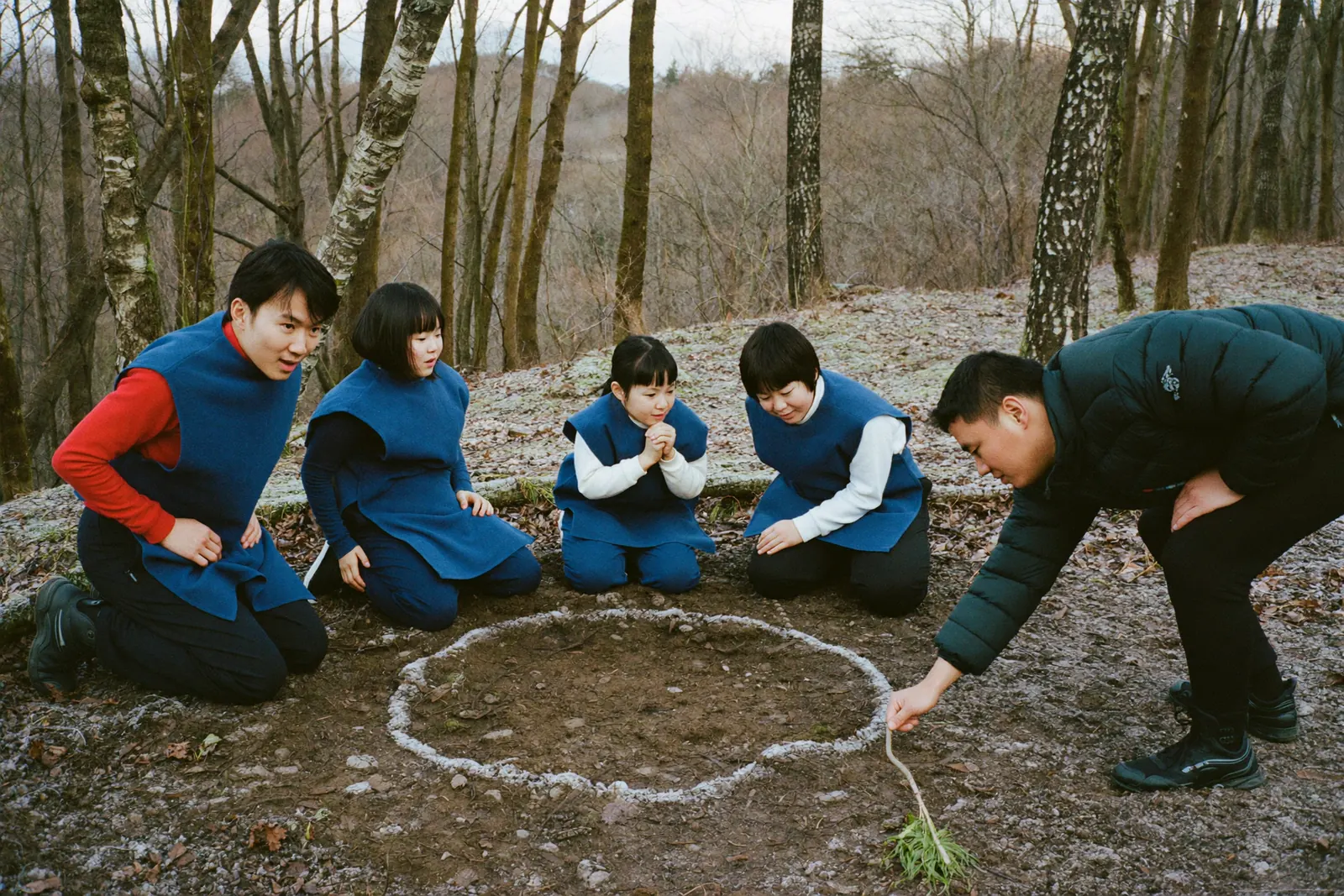 落ち葉の上で作戦を練る家族