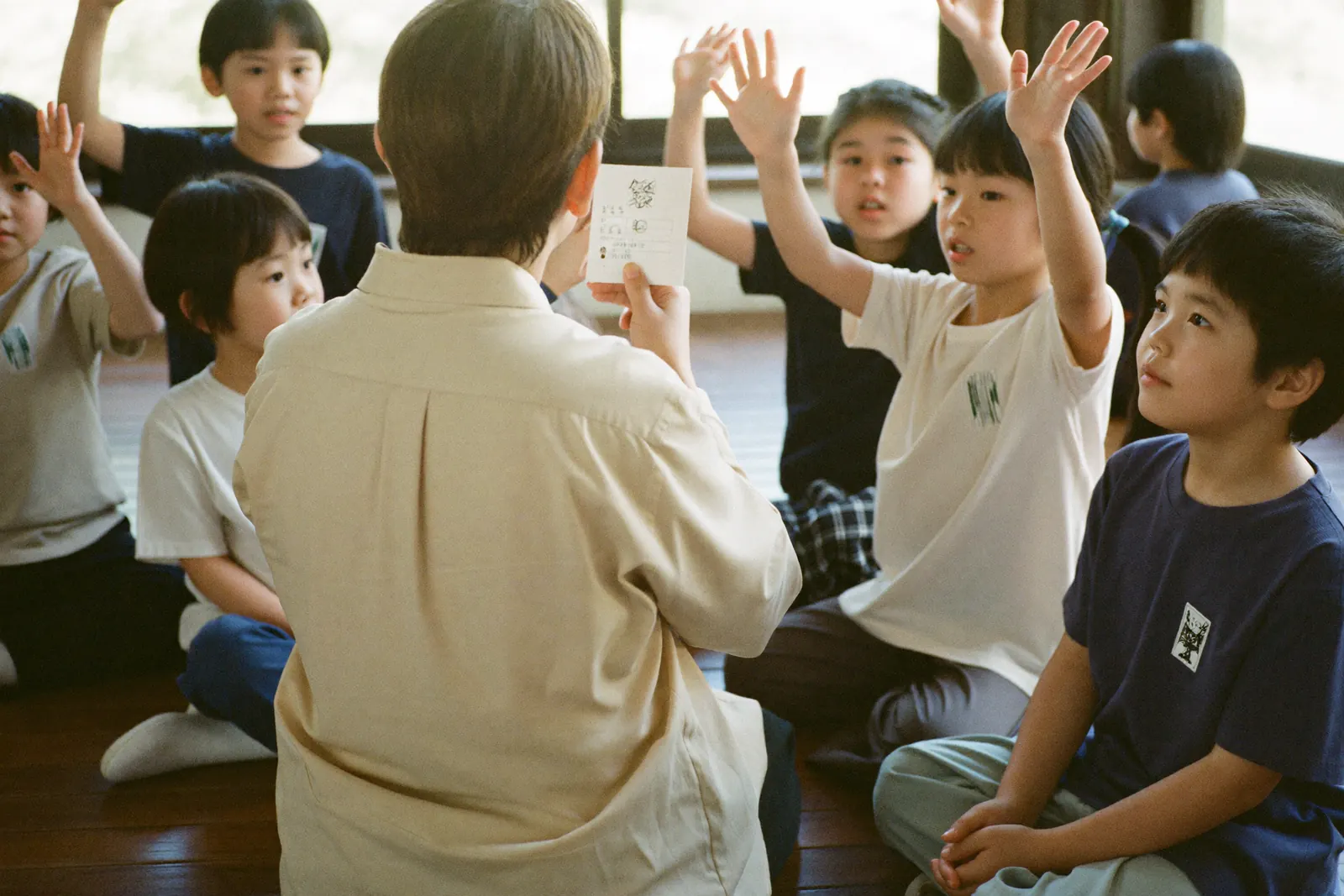 カードの絵柄を当てようと手を挙げる子どもたち