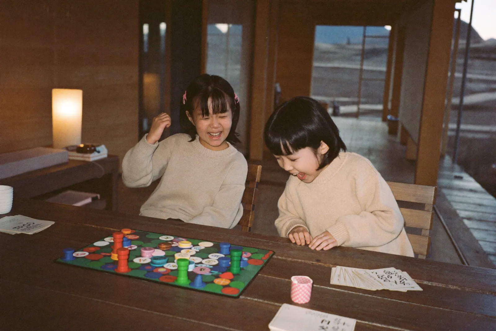 テーブルをかこんでボードゲームで対戦する子どもたち