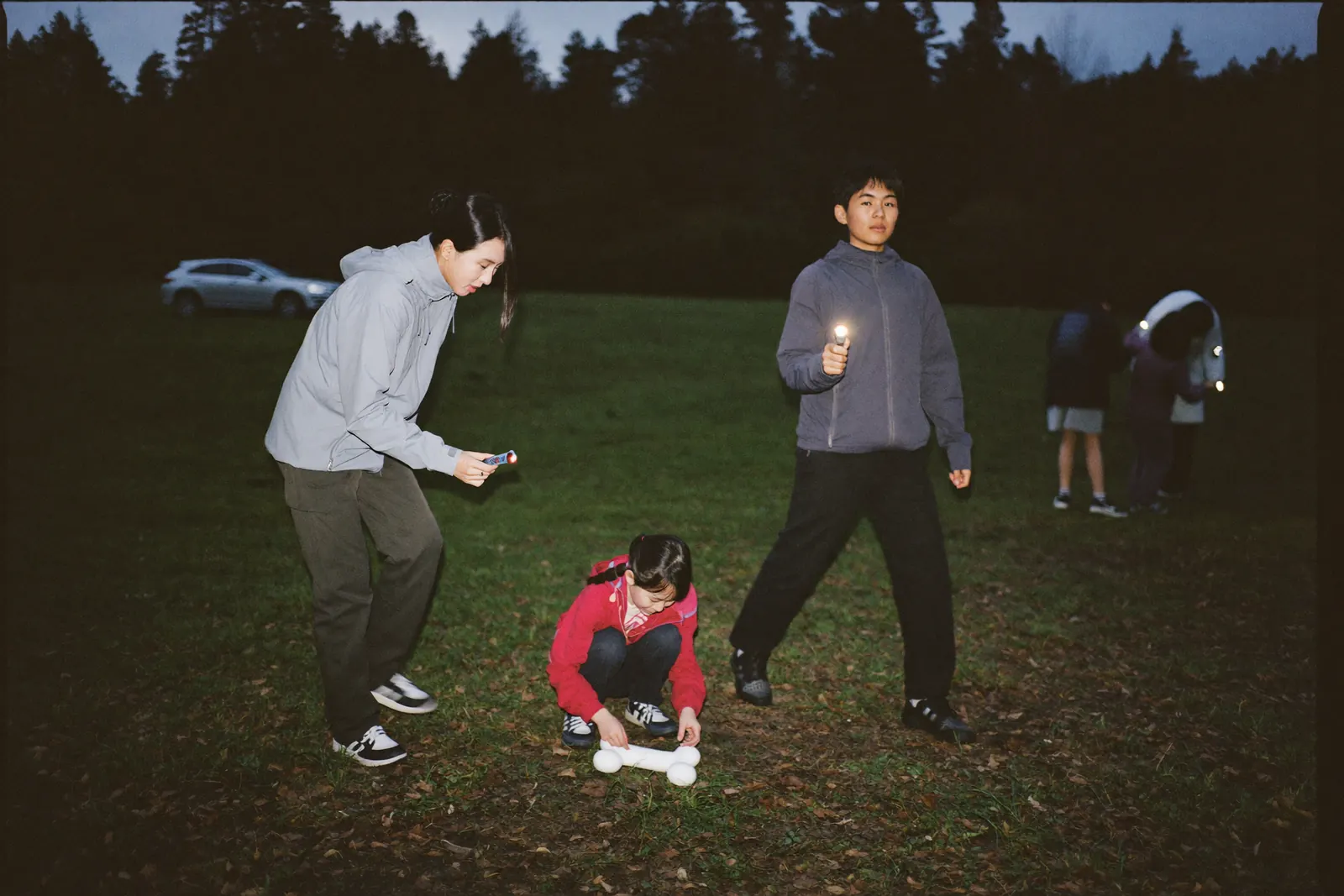 懐中電灯で骨を探す家族