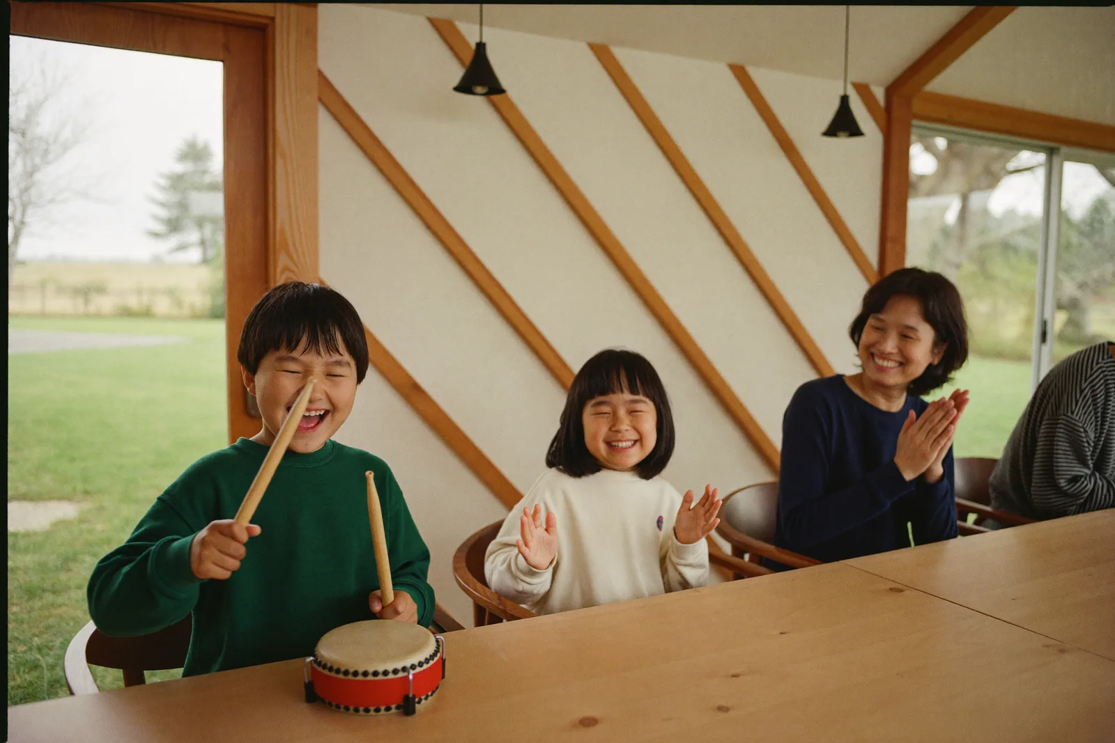 家族の前で太鼓をたたいて盛り上がる子どもたち