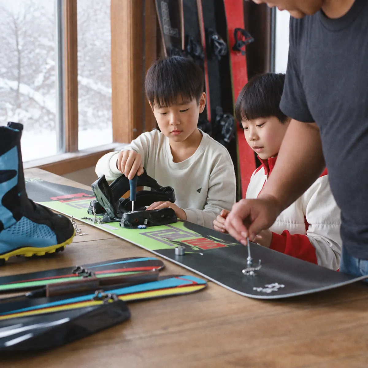 スノーボードのビンディングを分解する子どもたち