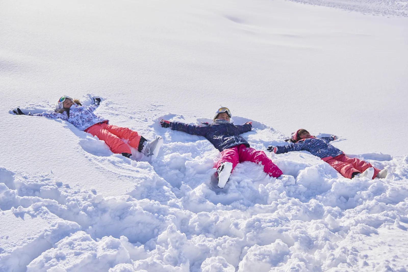 雪の上に寝ころんで遊ぶ子どもたち