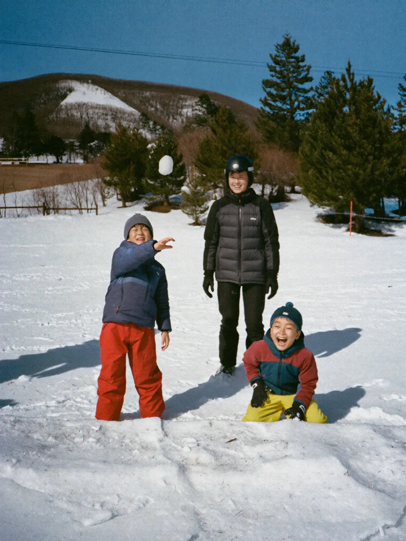 雪合戦で雪玉を投げる子どもたち