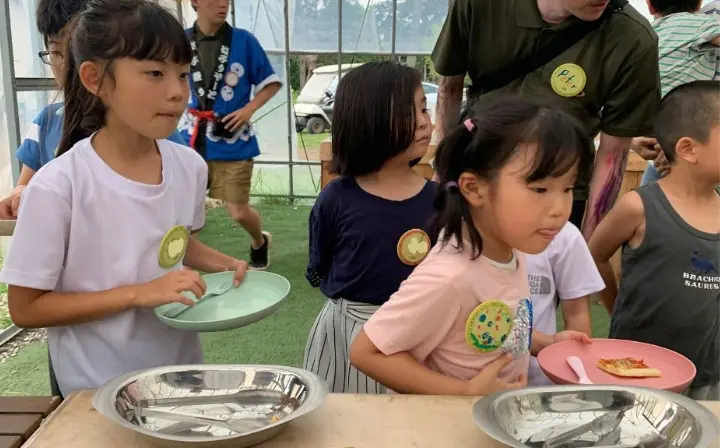 ビュッフェで料理を選ぶ子どもたち