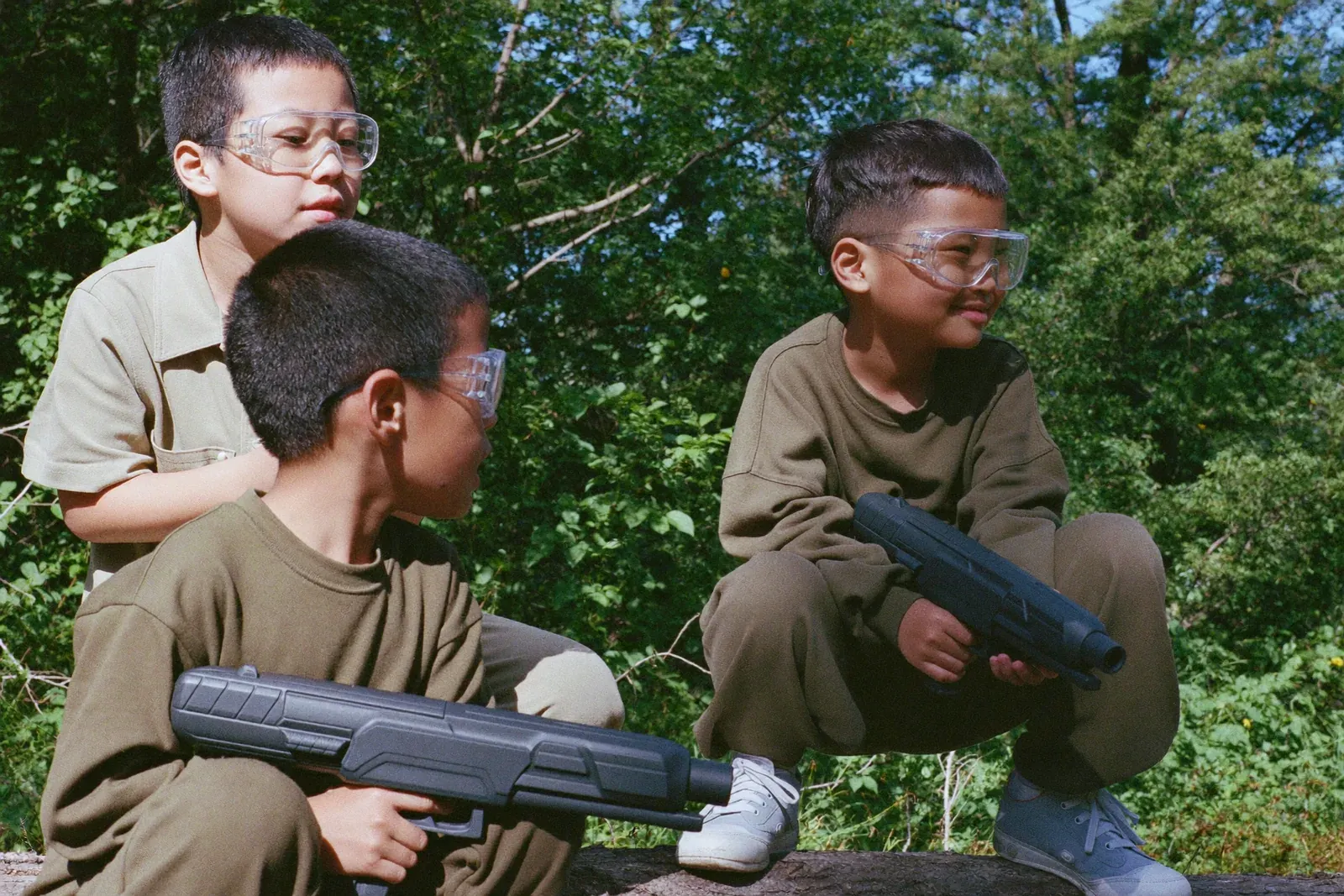 丸太の陰で作戦を立てる子どもたち