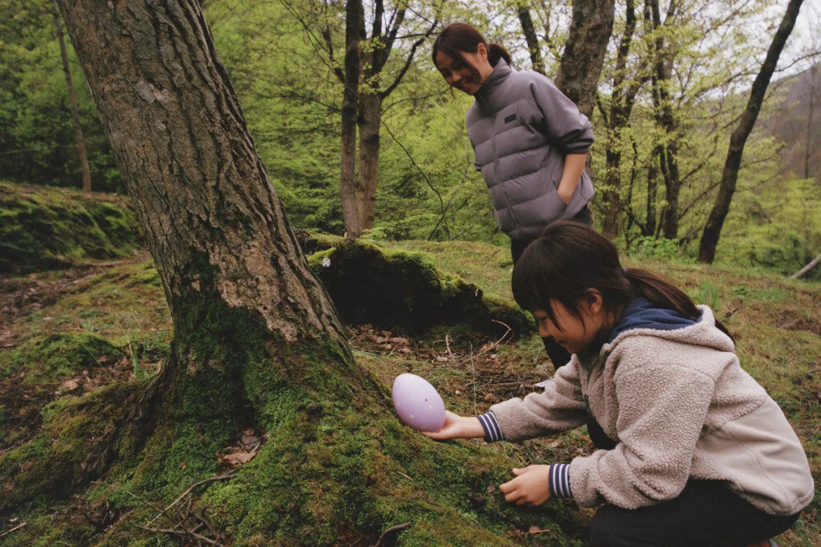 苔の上で卵を見つけた女の子