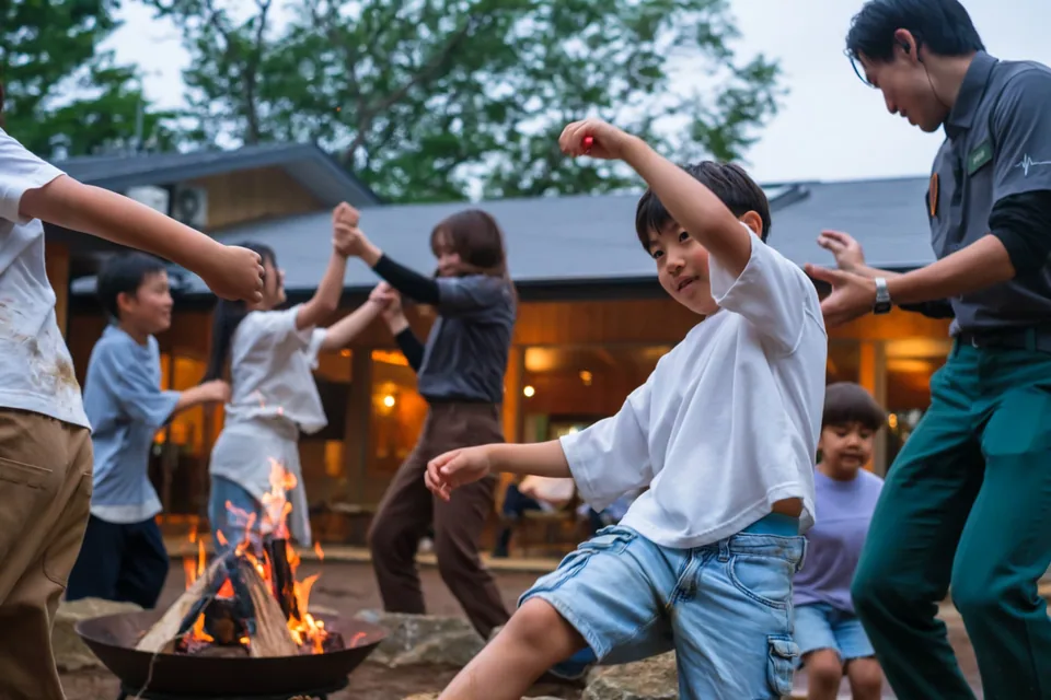 クルーと一緒にキャンプファイヤーで踊る子どもたち