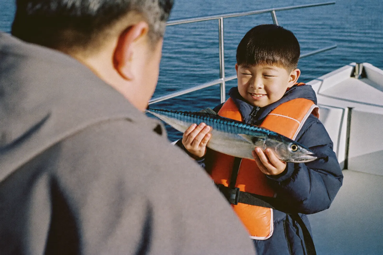 釣った魚を見せる男の子