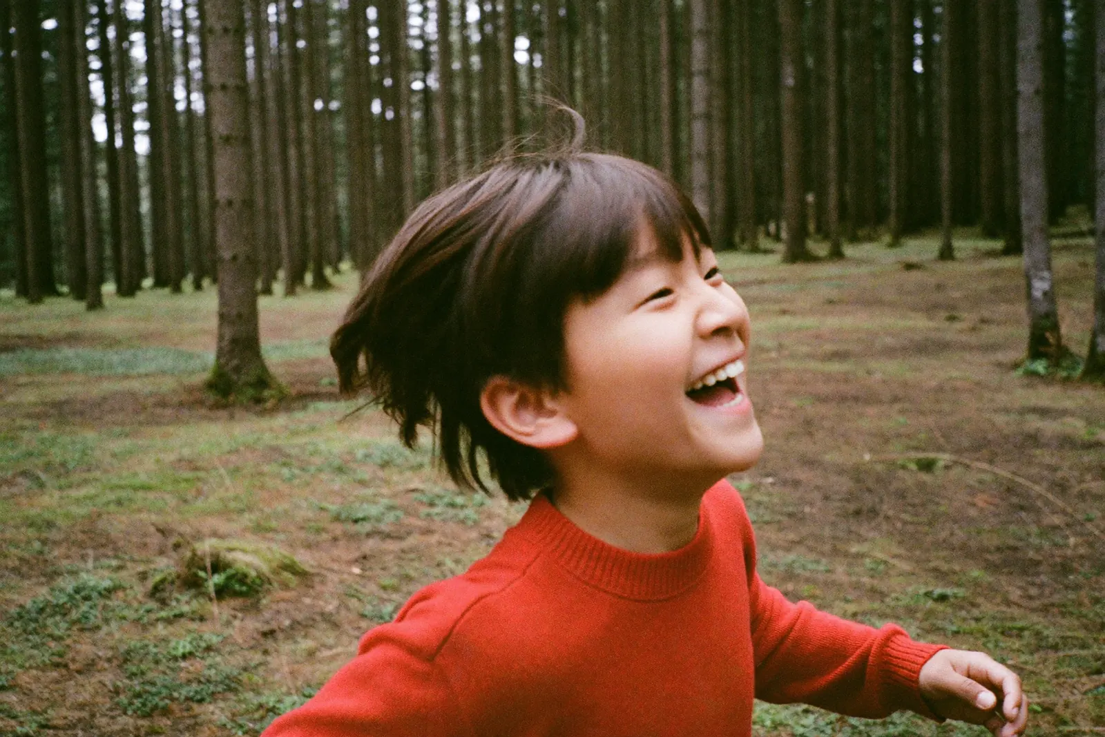 笑いながら森を走る男の子