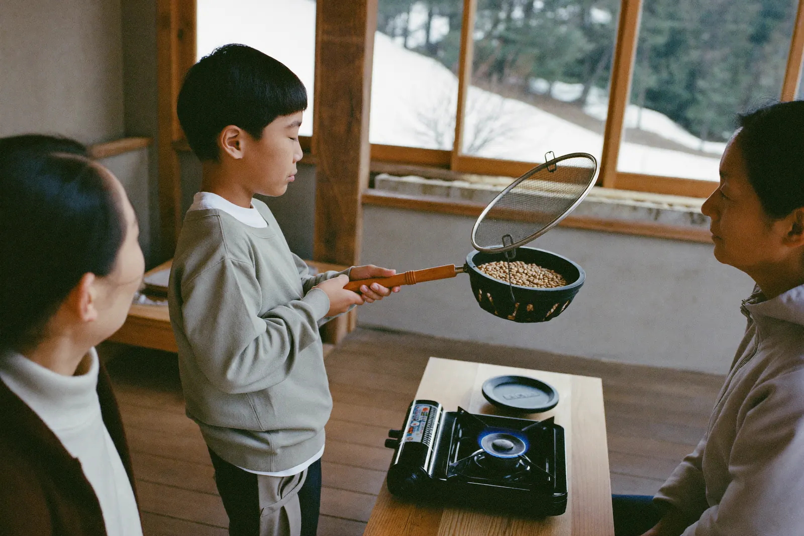 手網で珈琲豆を焙煎する男の子