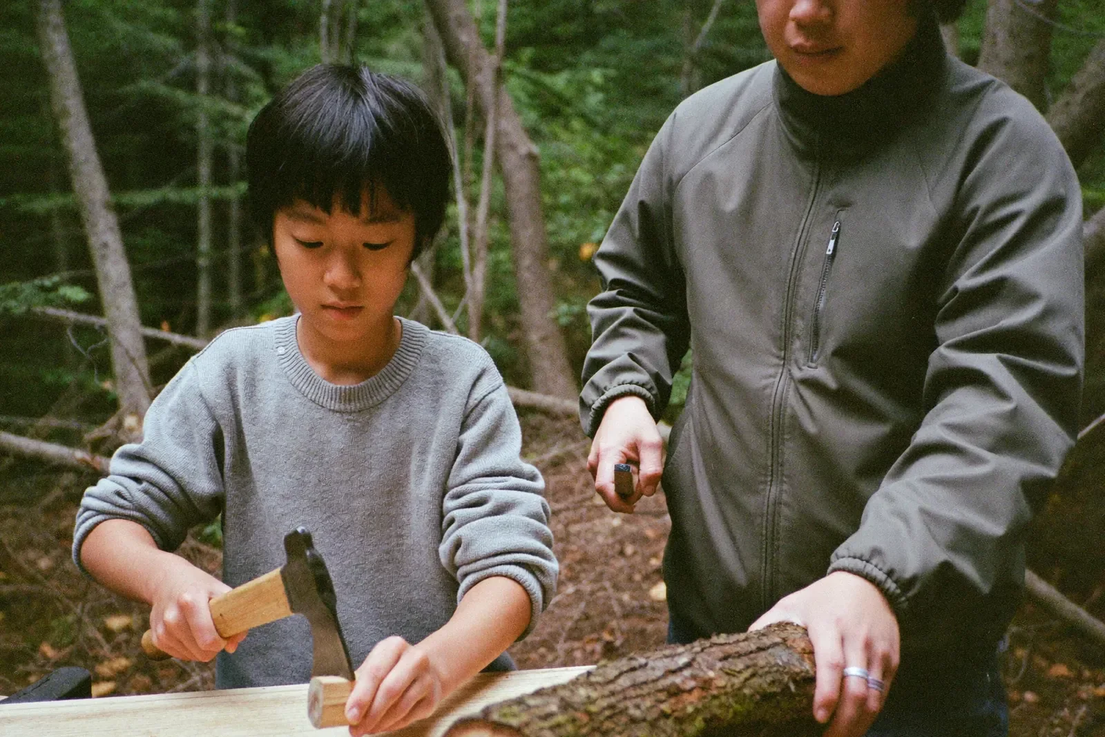 クルーに教わって薪を割る男の子