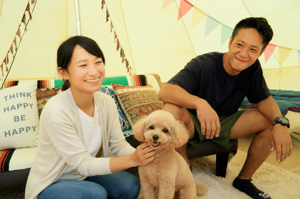 ベルテントで愛犬とくつろぐ夫婦
