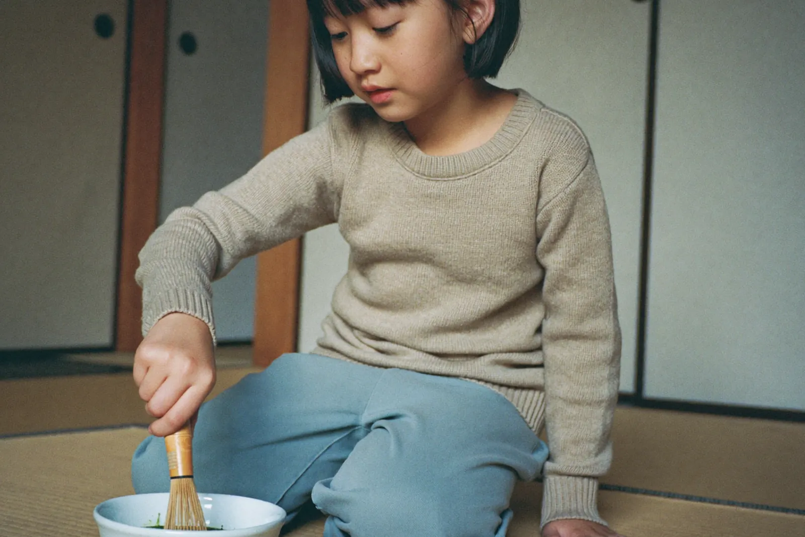畳の部屋で抹茶を点てる女の子