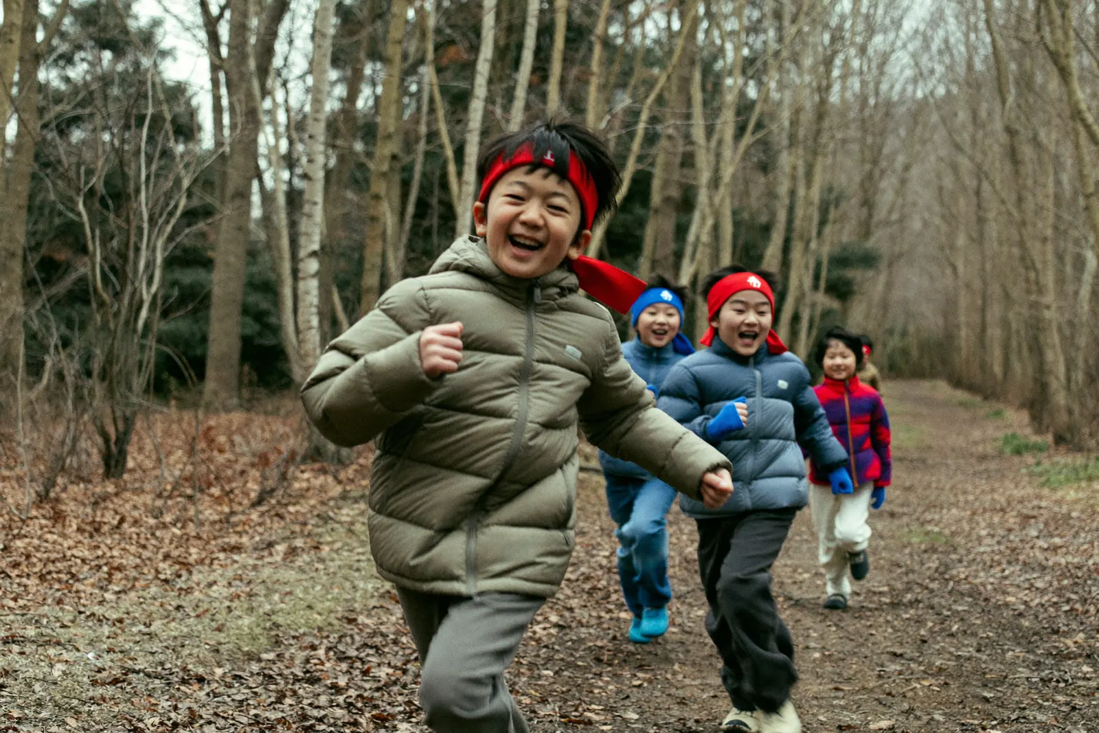 赤い鉢巻きで森を駆ける子どもたち