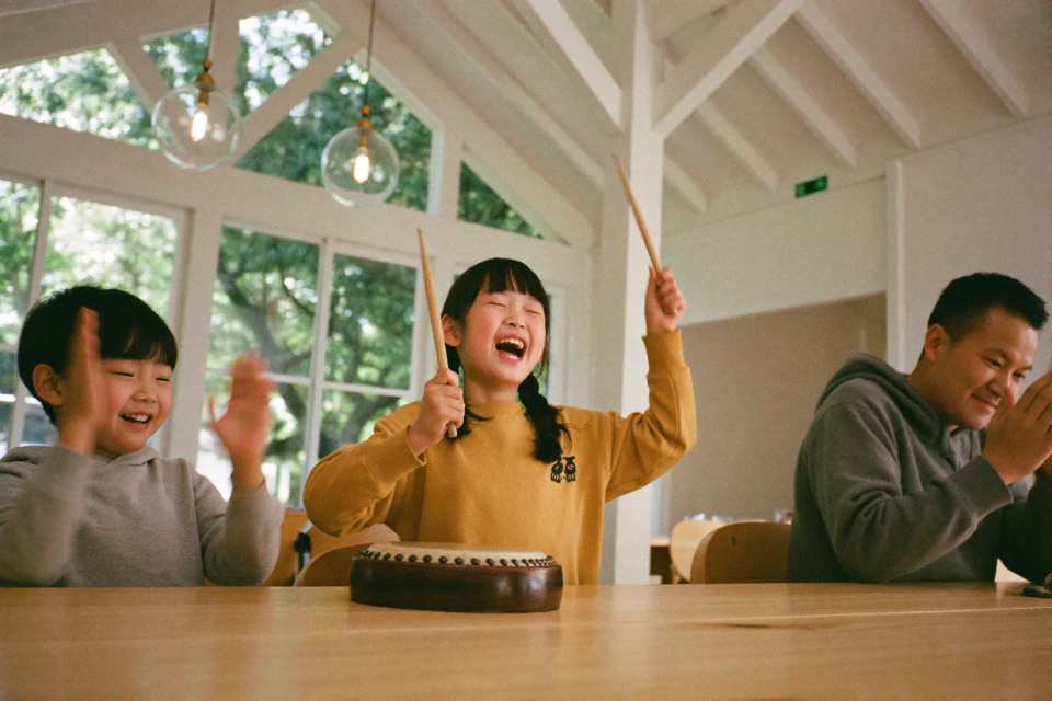 家族の前で太鼓をたたいて盛り上がる子どもたち