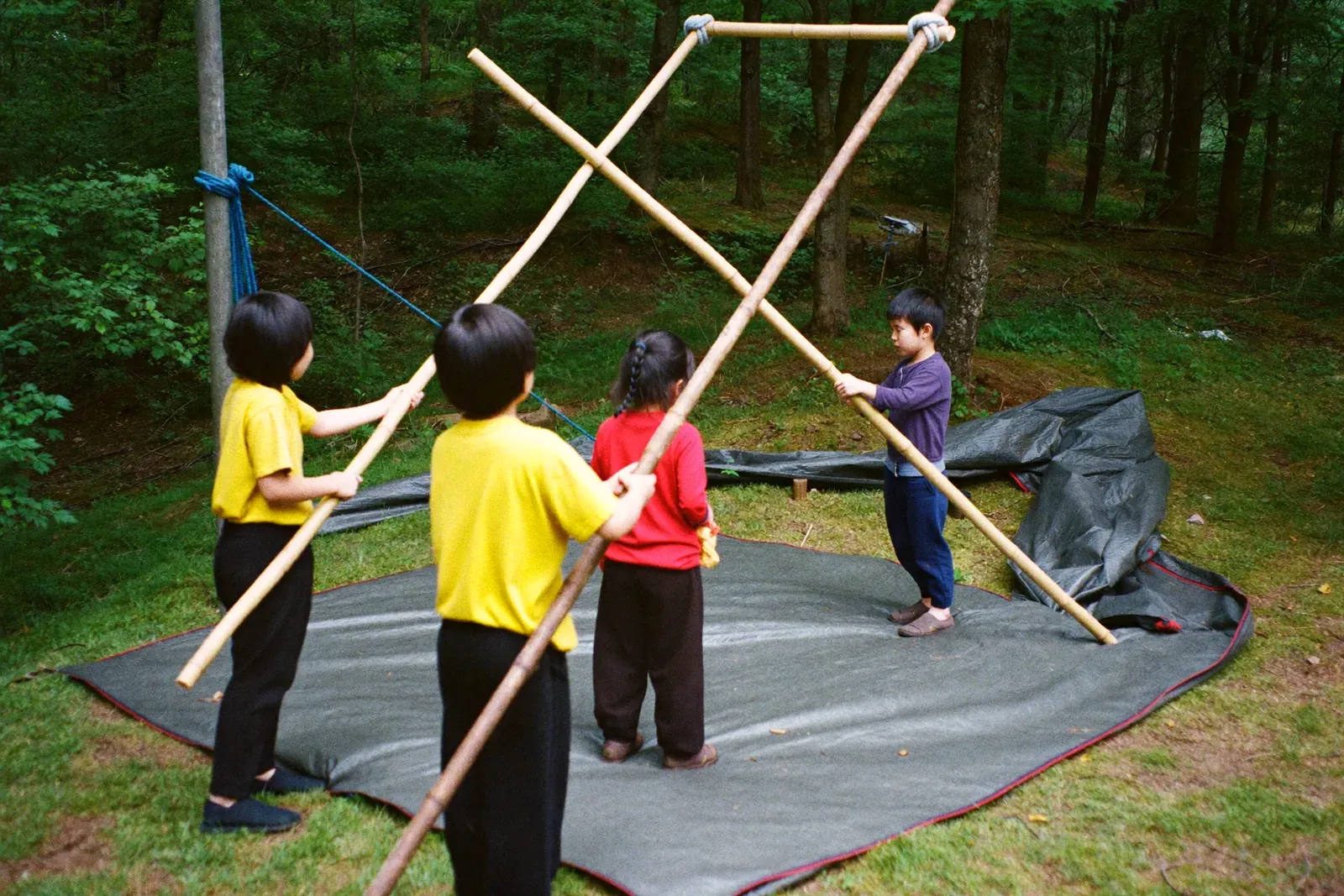 竹を組んで秘密基地をつくる子どもたち