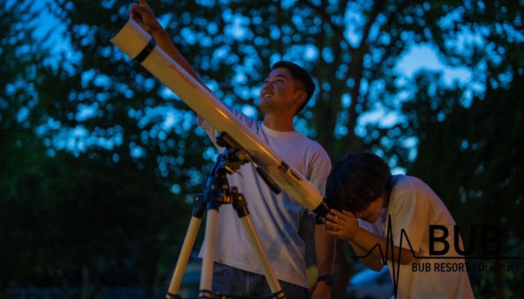 望遠鏡で星を見ている男女